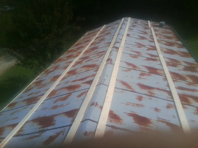 Rusted metal roof panels with new wood purlins before replacement — Storm Damage Roof Repair in Swanton by Roofing Brothers