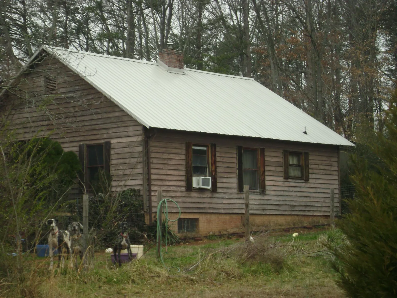 White metal roof on an old wood sided farmhouse, from a Metal Roof Installation job in Swanton
